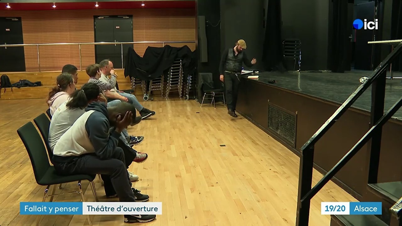 Jean-Michel sur scène devant un groupe de participants assis au bord du plateau